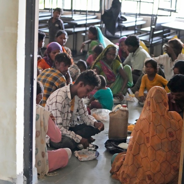 People evacuated from a village near Jakhau eat a meal at a shelter in Naliya, Kutch district, India, Wednesday, June 14, 2023. Cyclone Biparjoy is projected to make landfall near Jakhau port. The cyclone forecast to slam ashore on Thursday is expected to be the most powerful to hit western India and Pakistan since 2021. (AP Photo/Ajit Solanki)